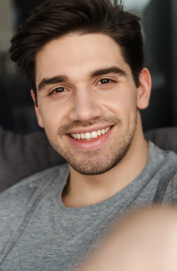 man smiling while sitting on couch